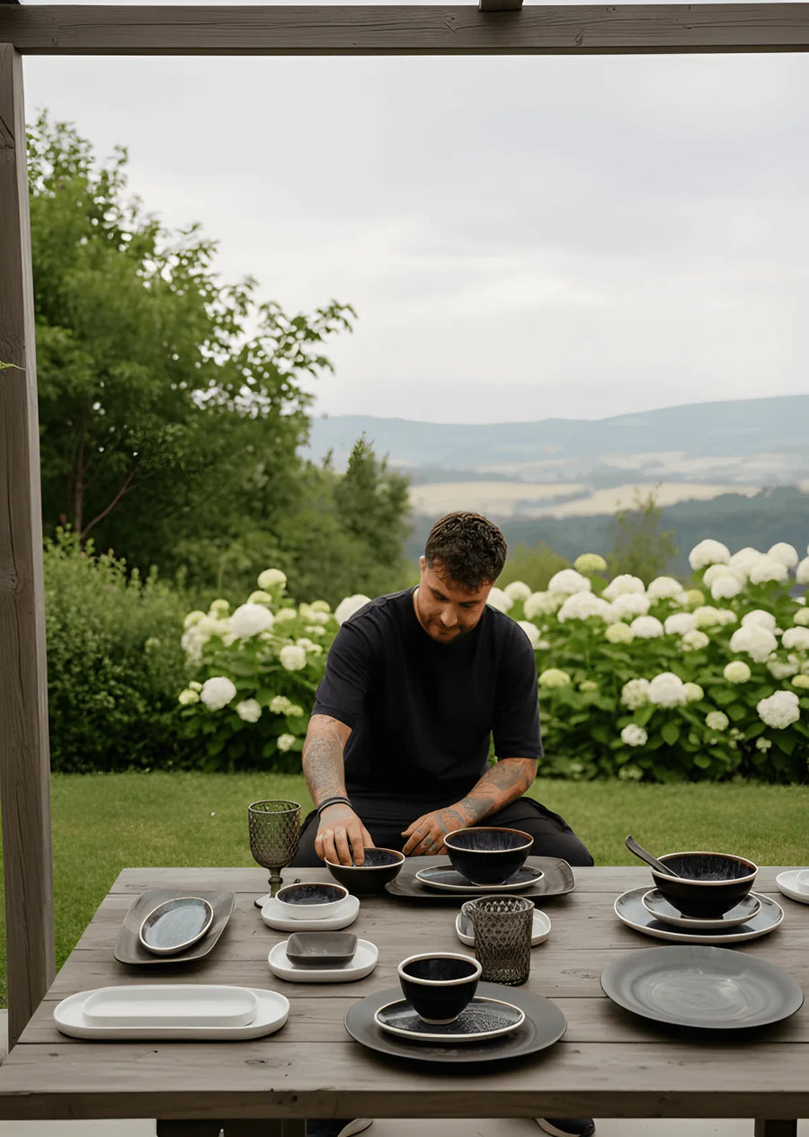 Une table dressée dans un jardin avec de la vaisselle