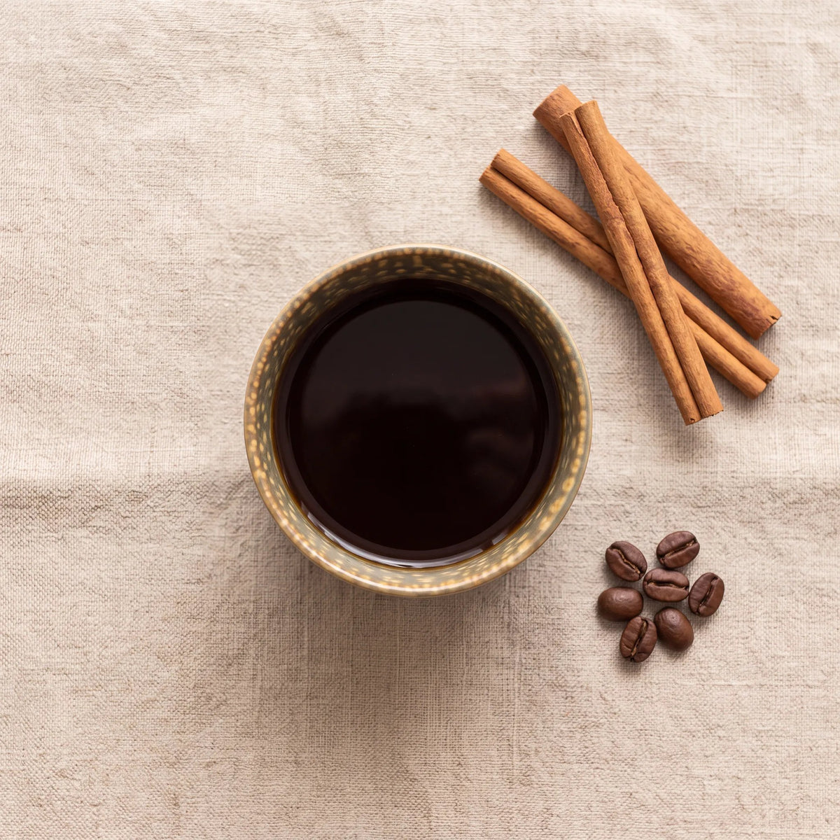 Cypress koffiekop met koffie, van boven gezien op linnen met kaneel en koffiebonen
