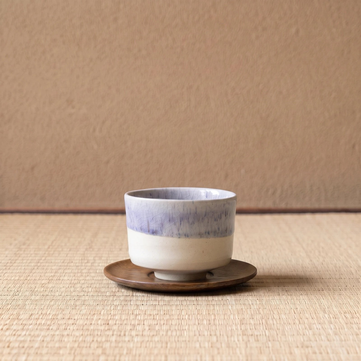 Winter Drift koffiekop op een houten onderzetter, op tatami voor een leemwand